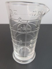 1930’s ENSIGN UK Footed Glass Embossed APOTHECARY MEASURE BEAKER Ounces & Drams