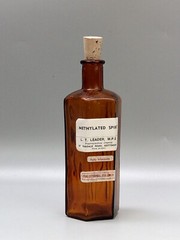 Vintage brown glass chemist bottle with label: Methylated Spirit L.T. Leader
