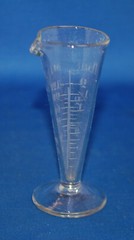 An antique apothecary measuring glass vessel, clear, engraved, fluted